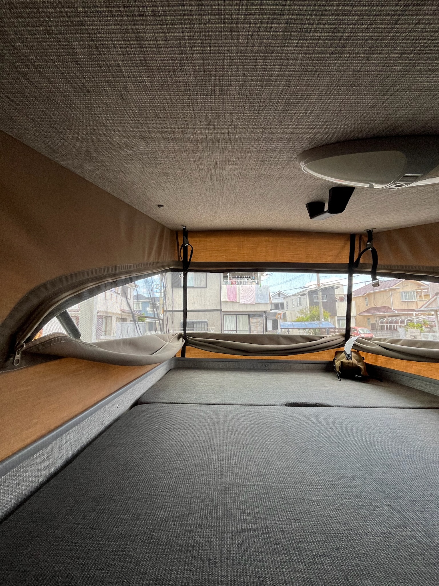 ポップアップルーフを開けた内側。広々としたベッドスペースと窓が見える